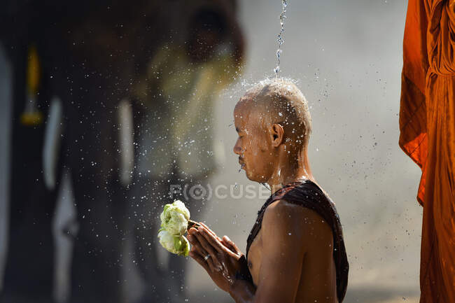 Porträt eines Mönchs, der einem anderen Mönch Wasser auf den Kopf gießt, Thailand — Stockfoto