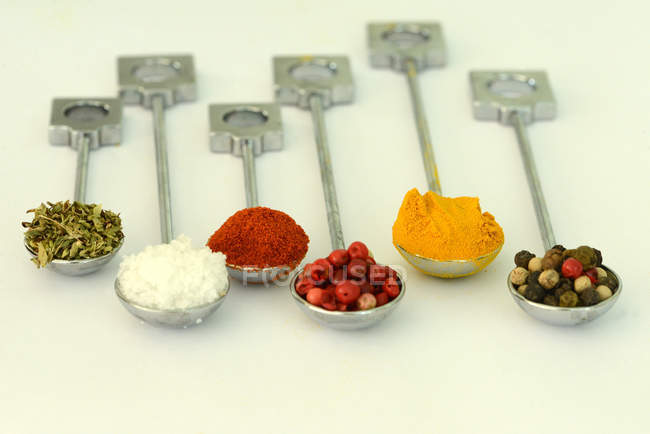 Spoons filled with spices over white background — Stock Photo