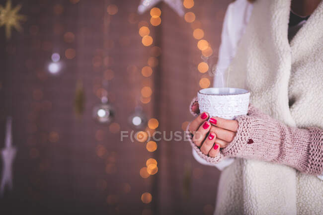 Donna che indossa scaldamani in possesso di una tazza di caffè — Foto stock