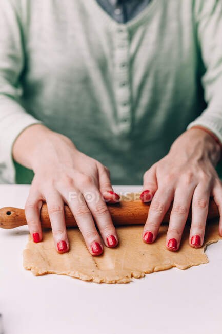 Mains de femme déroulant la pâte à biscuits — Photo de stock