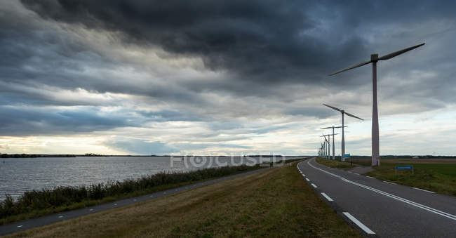 Vista panorámica de la carretera a través del paisaje rural, Zeewolde, Flevoland, Países Bajos - foto de stock