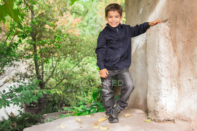 Портрет усміхненого хлопчика, що стоїть у парку — стокове фото