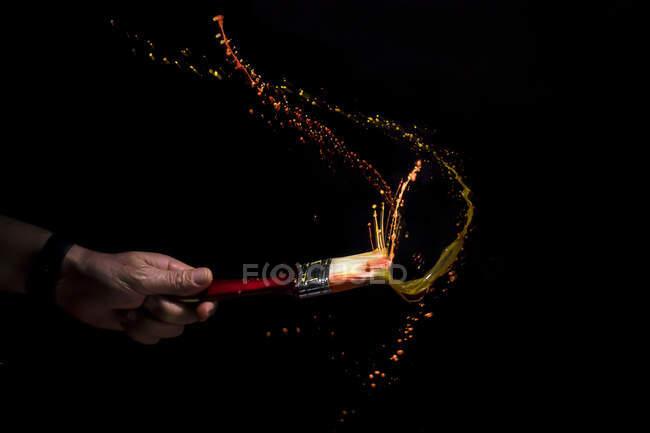 Menschliche Hand beim Schütteln eines Pinsels — Stockfoto