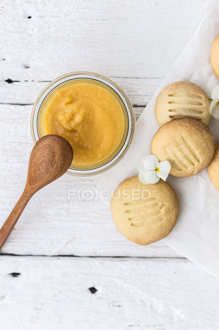 Pot of homemade lemon curd with melting moment biscuits — Stock Photo