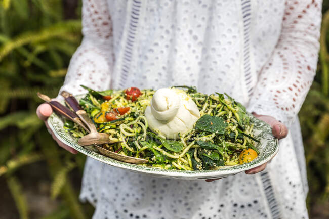 Donna che tiene un'insalata di zucchine estiva — Foto stock