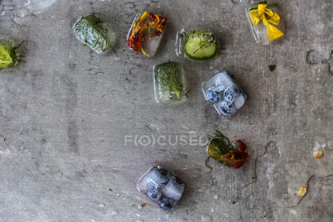 Visão de close-up dos cubos de gelo de frutas e ervas derretendo — Fotografia de Stock