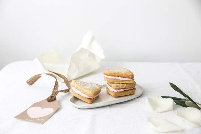 Песочное печенье в форме сердца над белым столом — стоковое фото