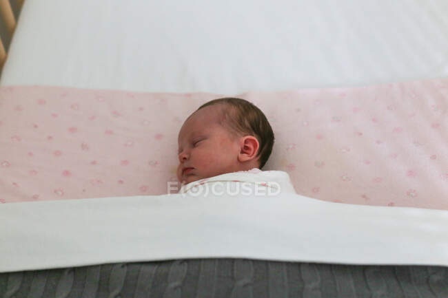 Baby girl sleeping in cot — Stock Photo