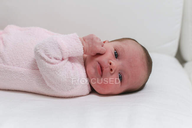Baby girl lying in a cot — Stock Photo