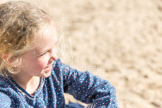 Close-up portrait of a girl sitting on beach — Stock Photo