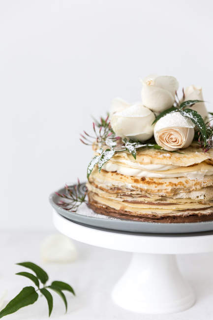 Layered Crepe Cake with cream and flower decoration — Stock Photo