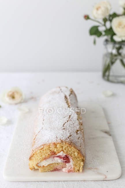 Strawberry sponge roll over white slab at kitchen — Stock Photo