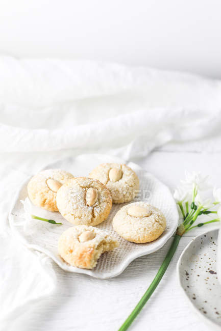 Plate of Almond Macaroons and a flower composition — Stock Photo