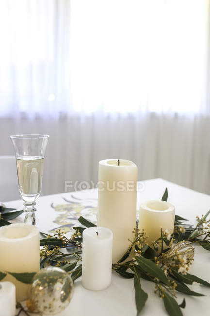Velas, eucaliptos e champanhe em uma mesa — Fotografia de Stock