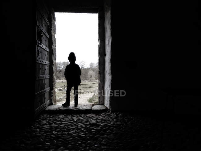 Silhouette eines Jungen, der in einer Tür steht — Stockfoto