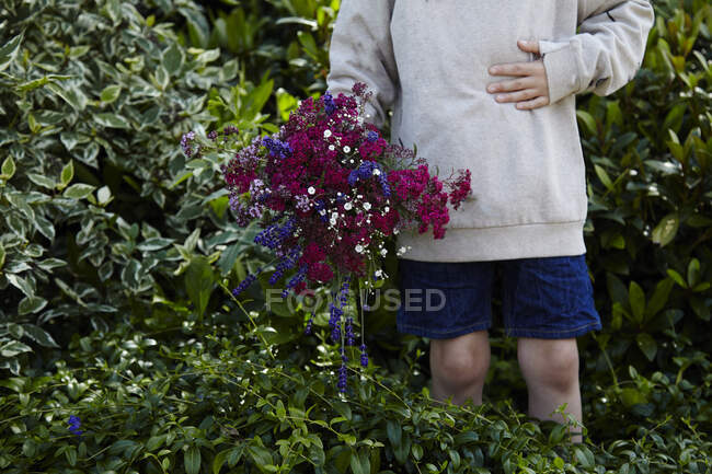 Boy holding a bouquet of flowers — Stock Photo