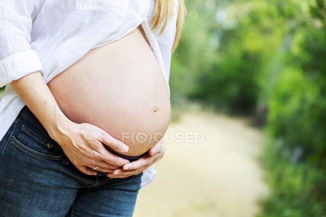Pregnant woman holding her belly — Stock Photo