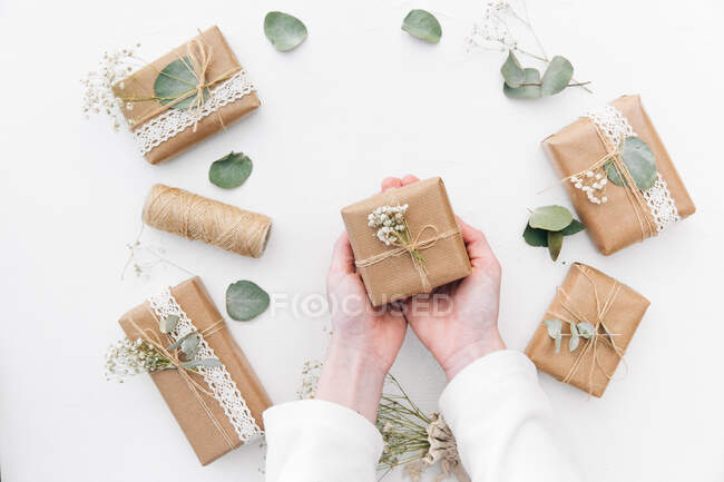 Руки жінки тримають загорнуті подарунки — стокове фото