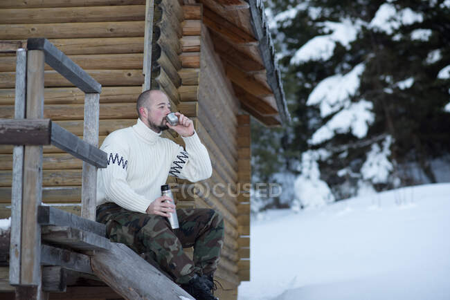 Чоловік сидить на веранді п'є чашку чаю — стокове фото