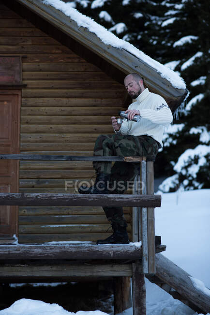 Mann sitzt auf Veranda und trinkt eine Tasse Tee — Stockfoto