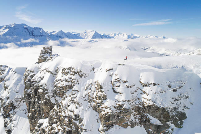 Hombre de pie en la montaña cubierta de nieve tomando un dronie, Salzburgo, Austria - foto de stock