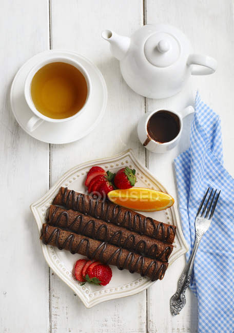 Chocolate crepes with tea over white table — Stock Photo