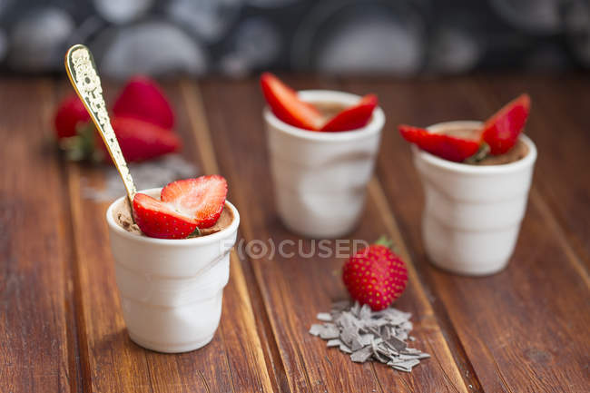Schokoladenmousse mit Erdbeeren über Holztisch — Stockfoto