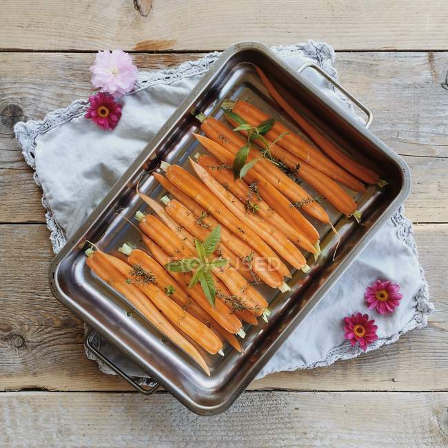 Vue de dessus des carottes coupées en deux dans une plaque à pâtisserie — Photo de stock