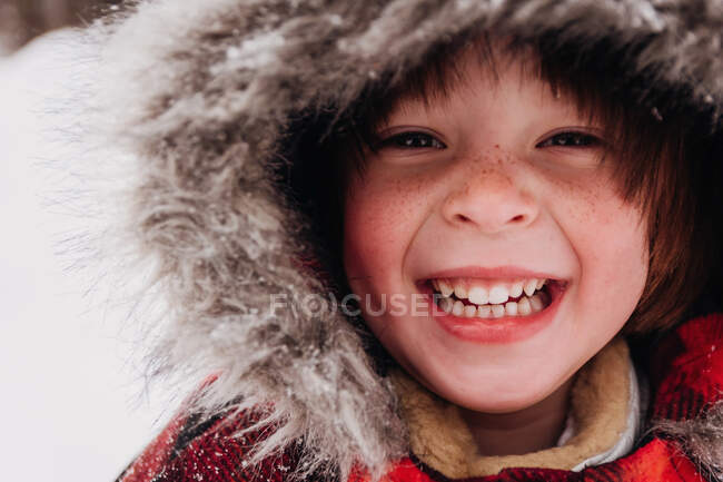 Retrato de una chica sonriente en parka encapuchada - foto de stock