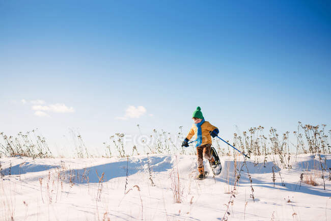 Хлопчик катається на снігоступах взимку на природі — стокове фото