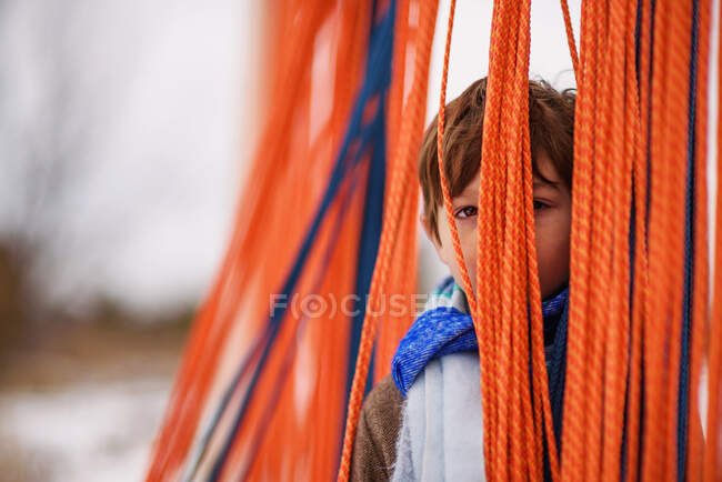 Boy hiding behind ropes in a playground — Stock Photo