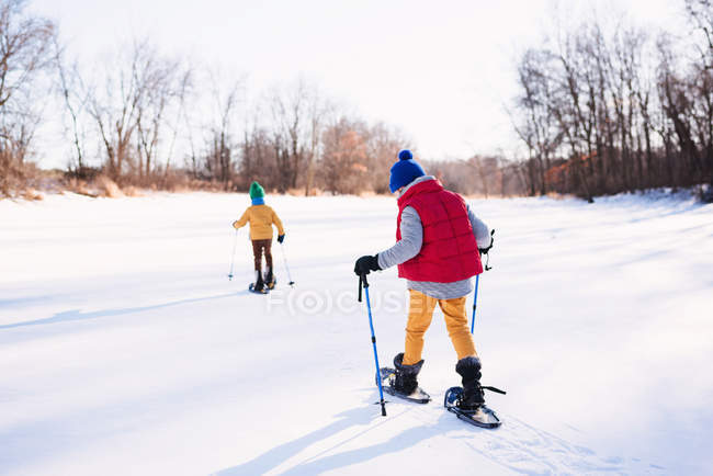 Dois meninos snowshoeing no inverno — Fotografia de Stock