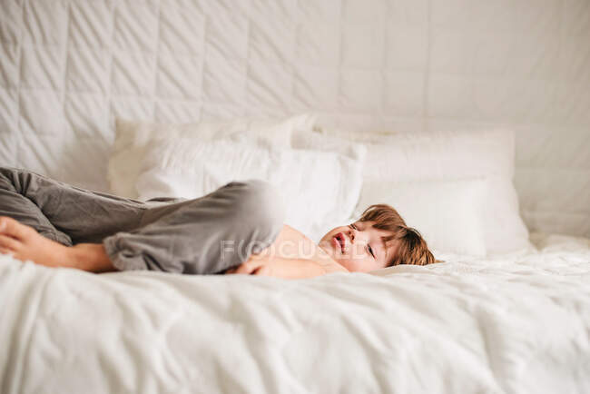 Adorable petit garçon couché sur le lit — Photo de stock