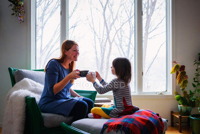 Mother and daughter toasting with cup of tea — Stock Photo