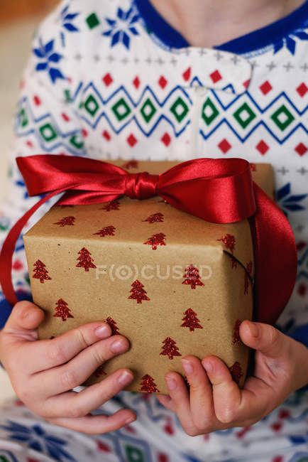 Vista de cerca de una chica sosteniendo un regalo de Navidad - foto de stock