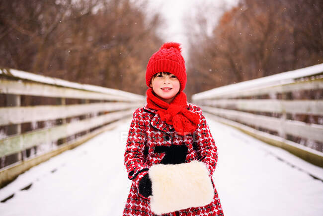 Mädchen steht mit falschem Pelzmuff auf Brücke im Schnee — Stockfoto