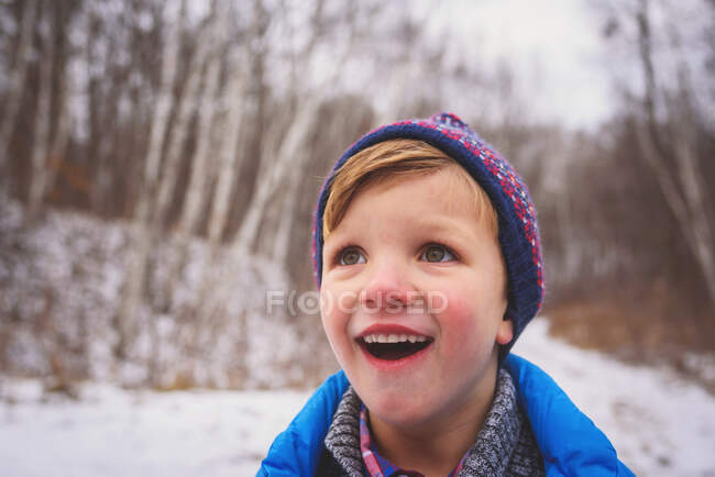 Portrait of a smiling boy in snow on nature — Stock Photo
