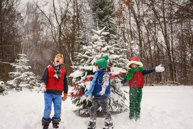 Троє дітей грають на снігу — стокове фото
