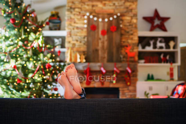 Ragazza piedi su un divano in soggiorno a Natale — Foto stock