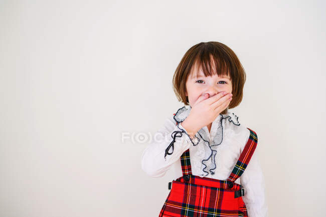 Retrato de una chica riéndose con la mano sobre la boca - foto de stock