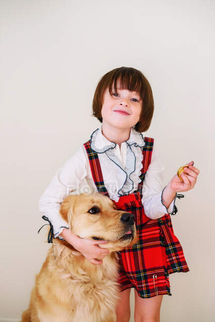Chica abrazando a su perro recuperador de oro - foto de stock