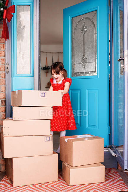 Девушка, стоящая у входной двери с доставкой коробок — стоковое фото