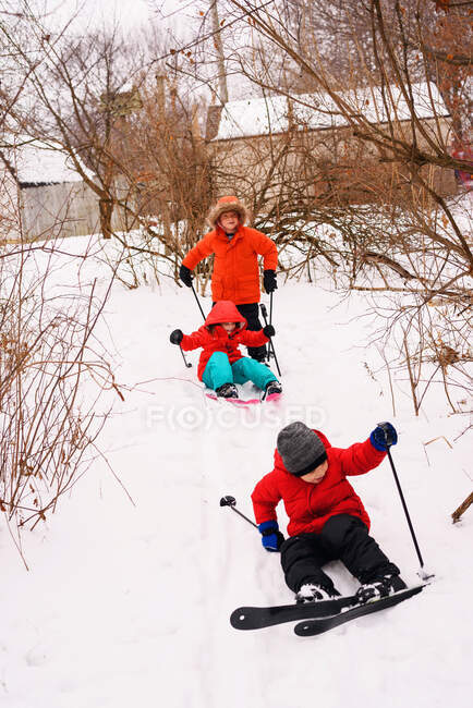 Три ребенка учатся кататься на лыжах — стоковое фото