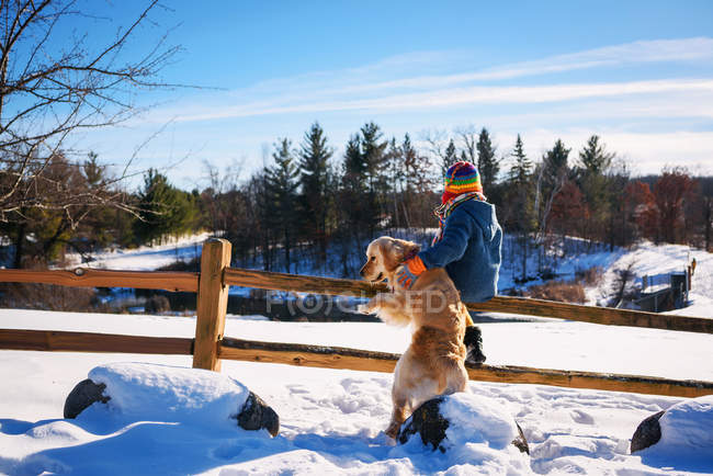 Garçon et chien debout sur la clôture — Photo de stock
