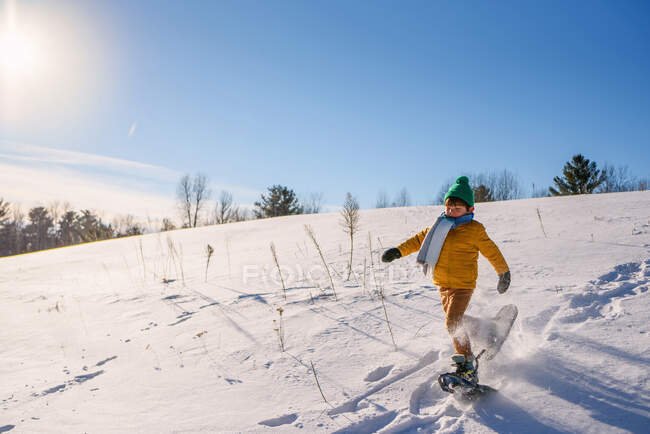 Retrato de menino snowshoeing para baixo colina — Fotografia de Stock