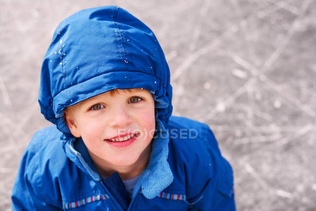 Портрет улыбающегося мальчика, стоящего на катке — стоковое фото