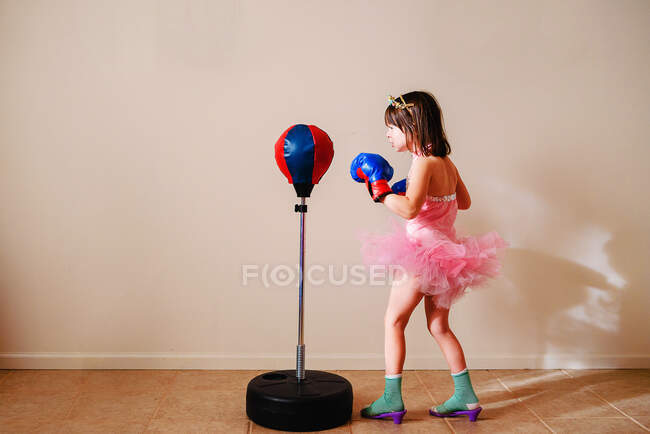 Chica en tutú rosa y zapatos de tacón alto aprendiendo a boxear - foto de stock
