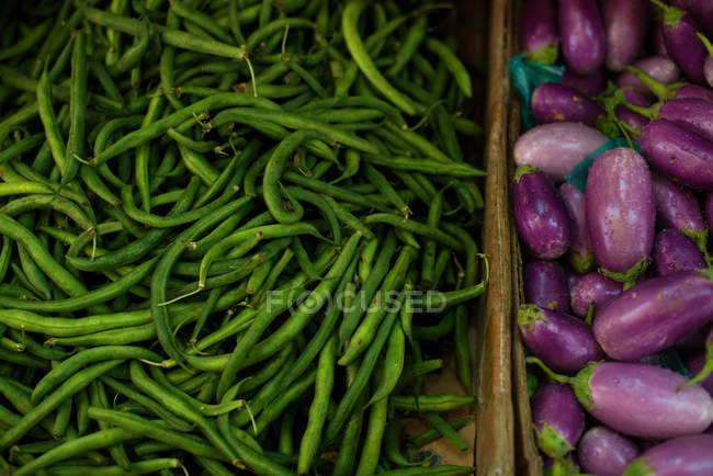 Vista de primer plano de judías verdes y berenjenas en el mercado - foto de stock