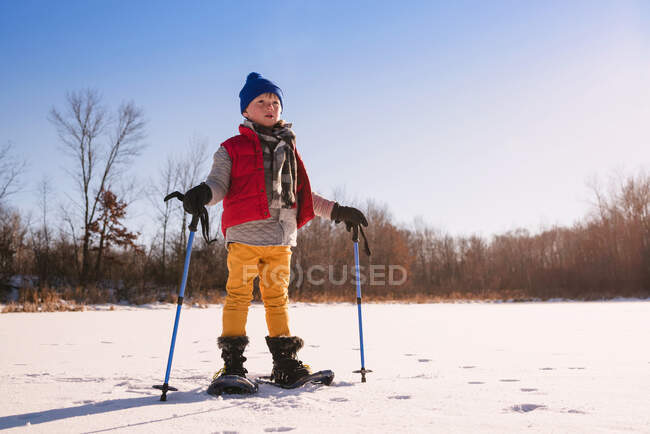 Menino snowshoeing no dia ensolarado de inverno — Fotografia de Stock
