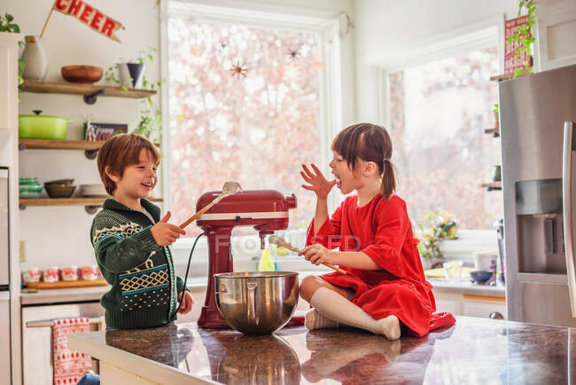 Two children eating raw cookie dough — Stock Photo